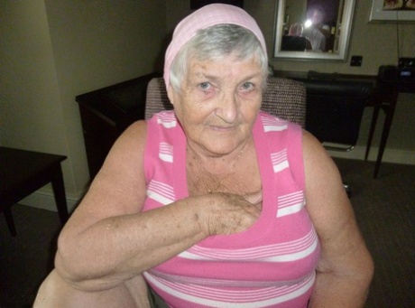 Obese grandmother licks her own nipples as she strips naked in living room