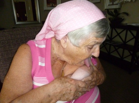 Obese grandmother licks her own nipples as she strips naked in living room