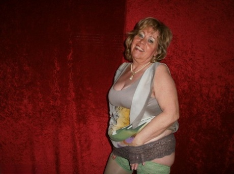 Chubby mature granny Caro in green stockings flashes lace panty cameltoe