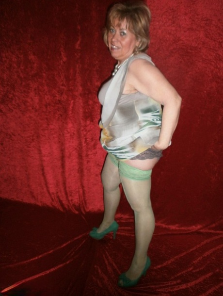 Chubby mature granny Caro in green stockings flashes lace panty cameltoe
