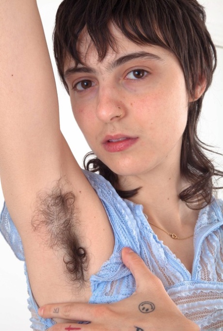 Tattooed girl with furry armpits stretches her really hairy cunt out
