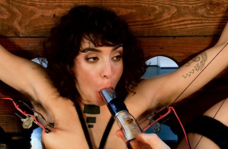 Flexible chick is restrained while being subjected to lesbian electro sex