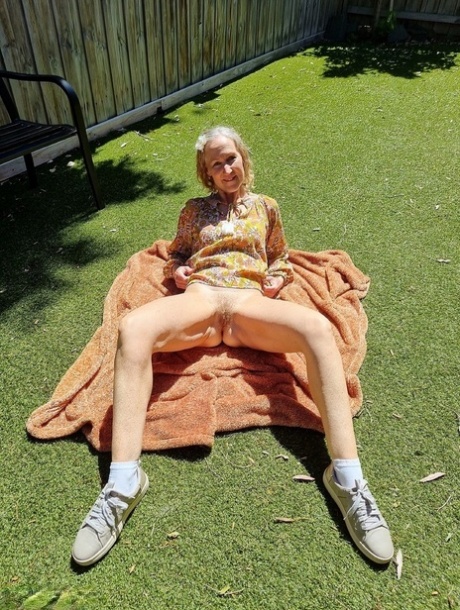 Old blonde woman Jacqueline goes nude on a blanket in socks and running shoes