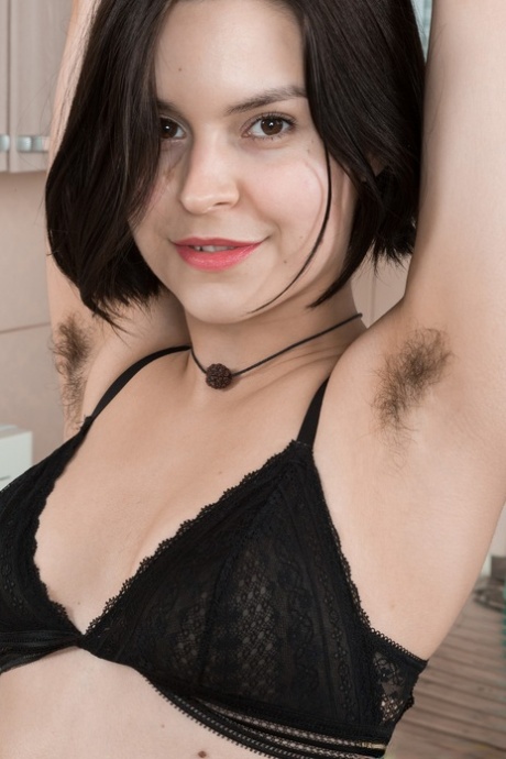 Hairy brunette Ole Nina strips naked and plays with herself in the kitchen