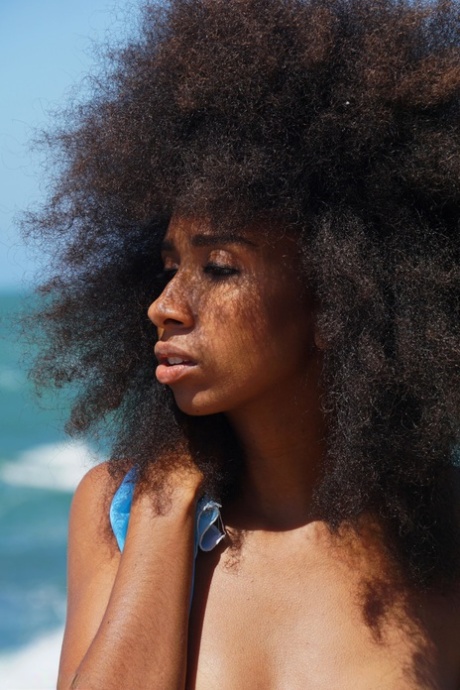Curly-haired ebony teen Isadora posing butt naked on the sandy beach