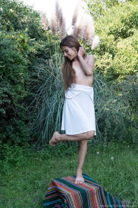 Naughty amateur Alice Mad strips naked & spreads her hairy pussy outdoors