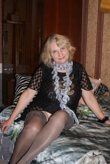 Chubby granny Helga shows off her saggy tits while undressing in her bedroom