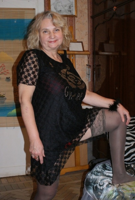 Chubby granny Helga shows off her saggy tits while undressing in her bedroom